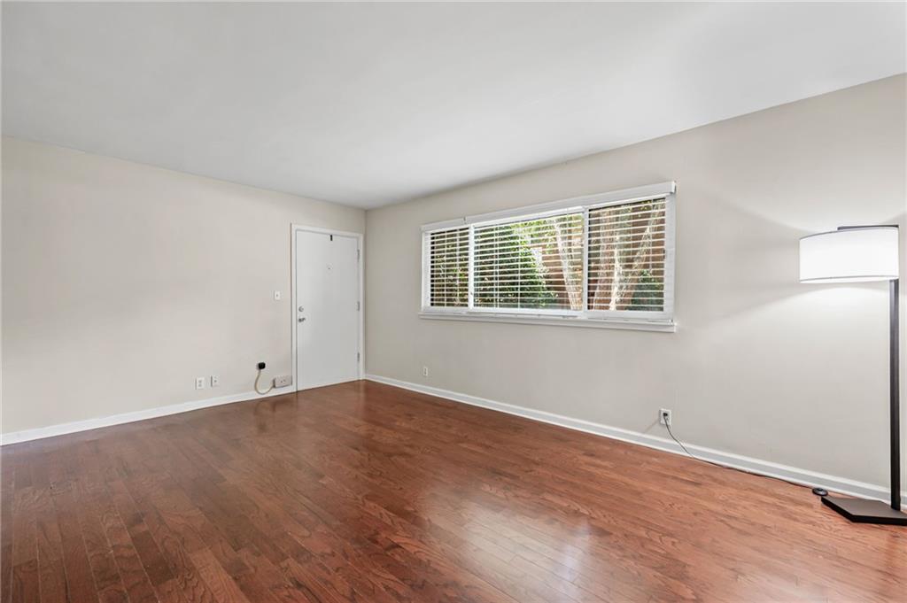 20 26th Street Northwest, Unit A1 Atlanta, GA 30309 - Photo 5 of 19 a view of an empty room with wooden floor and a window