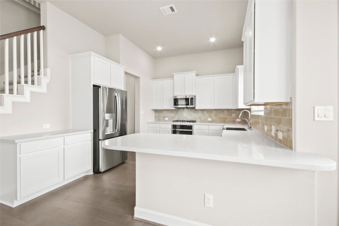 136 Peninsula Point Drive Montgomery, TX 77356 - Photo 6 of 30 a kitchen with stainless steel appliances a refrigerator sink and microwave