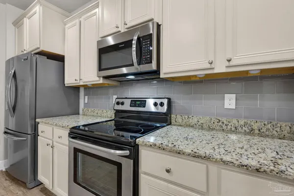 a kitchen with granite countertop cabinets and steel stainless steel appliances