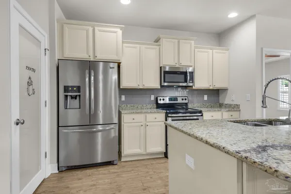 a kitchen with stainless steel appliances granite countertop a refrigerator stove a sink and a granite counter tops