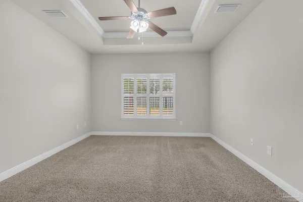 an empty room with a window and a fan