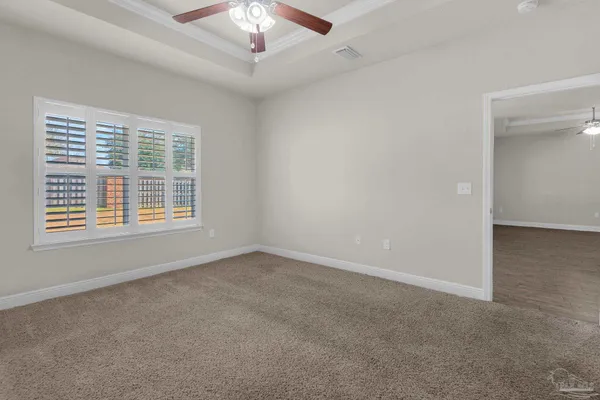 en empty room with windows and chandelier fan