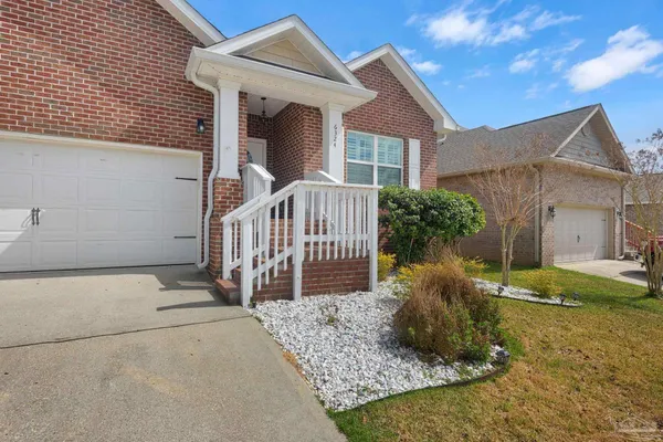 a view of a house with a yard and fence