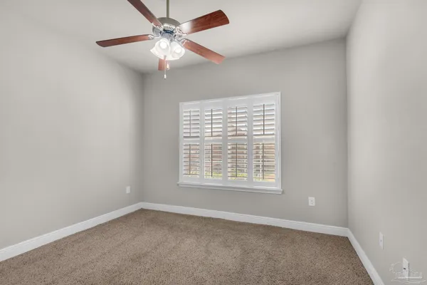 an empty room with a window and a fan