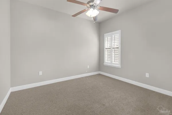 an empty room with windows and fan