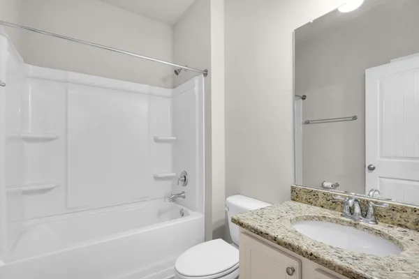 a bathroom with a granite countertop sink toilet bathtub and shower