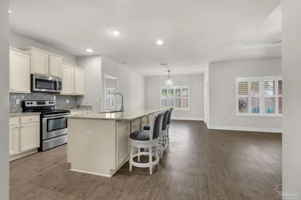 a kitchen with a table chairs microwave and cabinets
