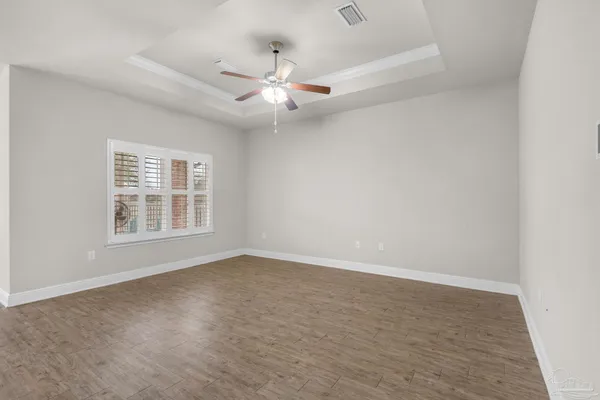 an empty room with windows and fan