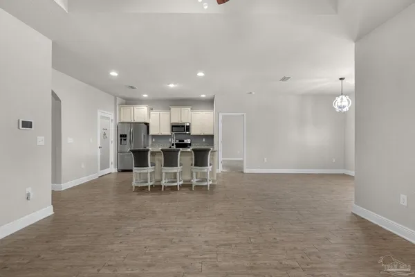 a view of kitchen with refrigerator stove and chairs