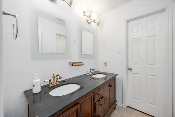 a bathroom with a granite countertop sink a toilet and shower