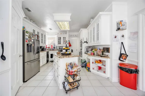 a kitchen with stainless steel appliances kitchen island granite countertop a stove a sink and a refrigerator