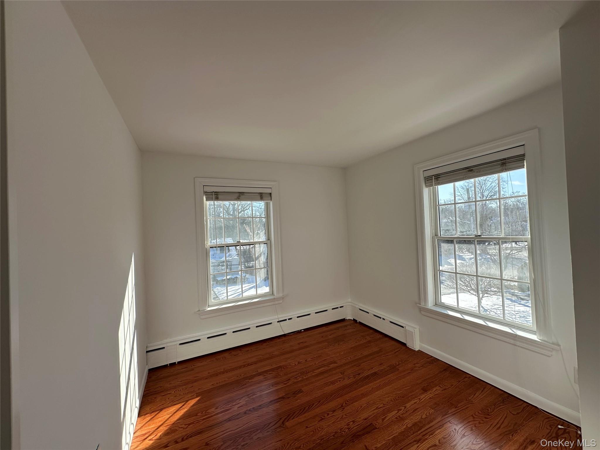 197 Johnson Road Scarsdale, NY 10583 - Photo 14 of 36 Bedroom with a baseboard radiator and dark hardwood / wood-style floors and two windows