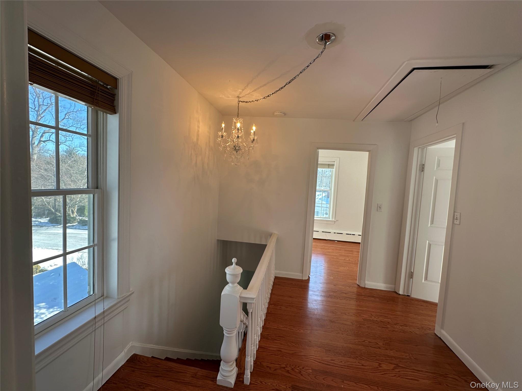 197 Johnson Road Scarsdale, NY 10583 - Photo 15 of 36 Hall with dark hardwood / wood-style flooring, a baseboard heating unit, and a chandelier