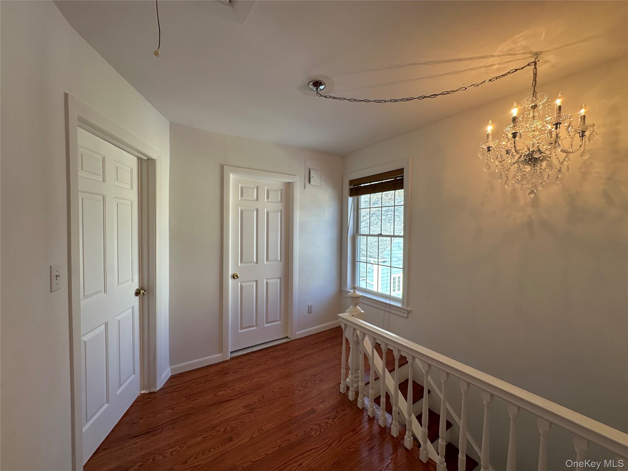197 Johnson Road Scarsdale, NY 10583 - Photo 17 of 36 Hall with a chandelier and hardwood / wood-style floors