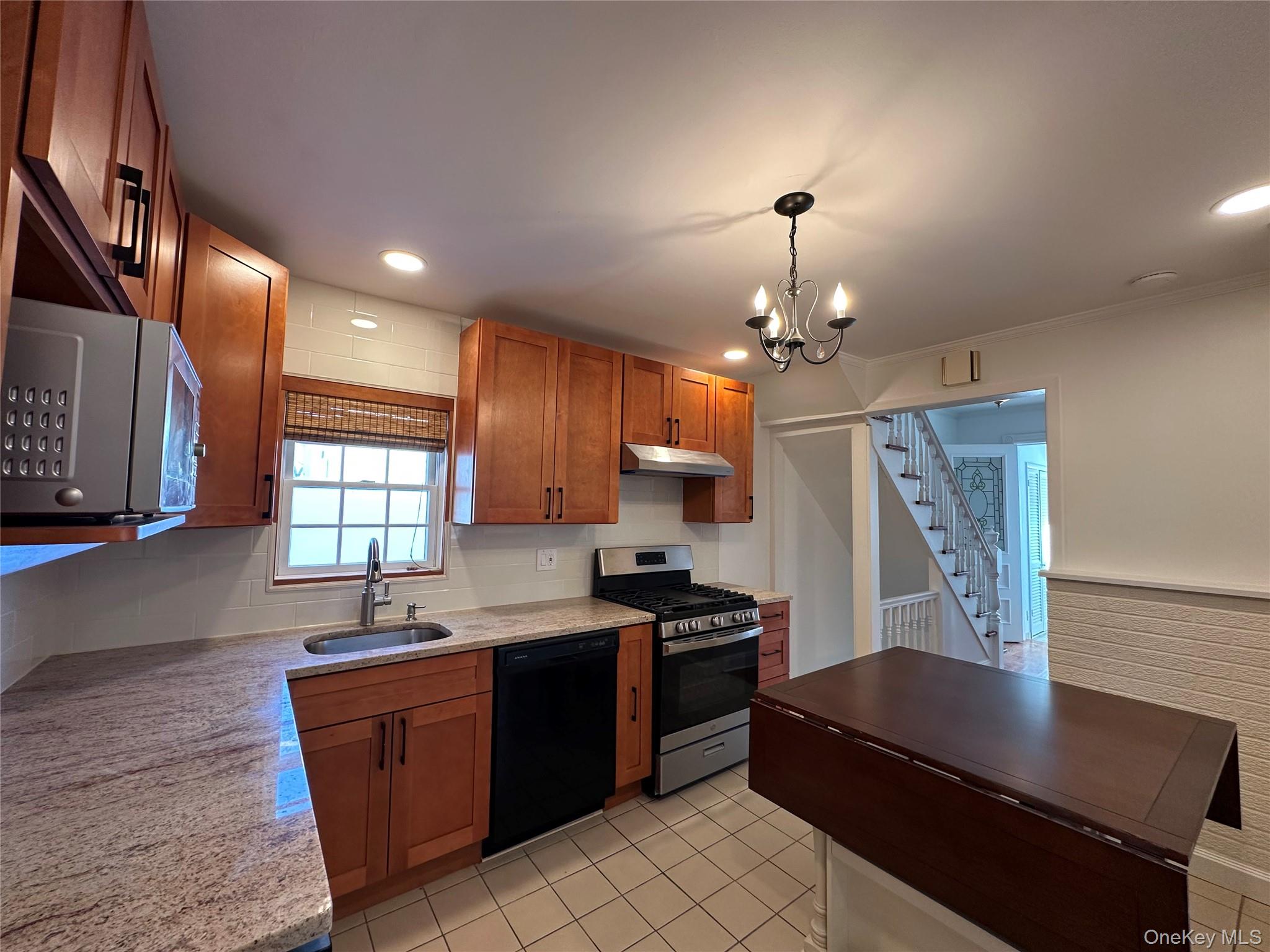197 Johnson Road Scarsdale, NY 10583 - Photo 19 of 36 Eat-In Kitchen with sink, ornamental molding, appliances with stainless steel finishes, a notable chandelier, and pendant lighting