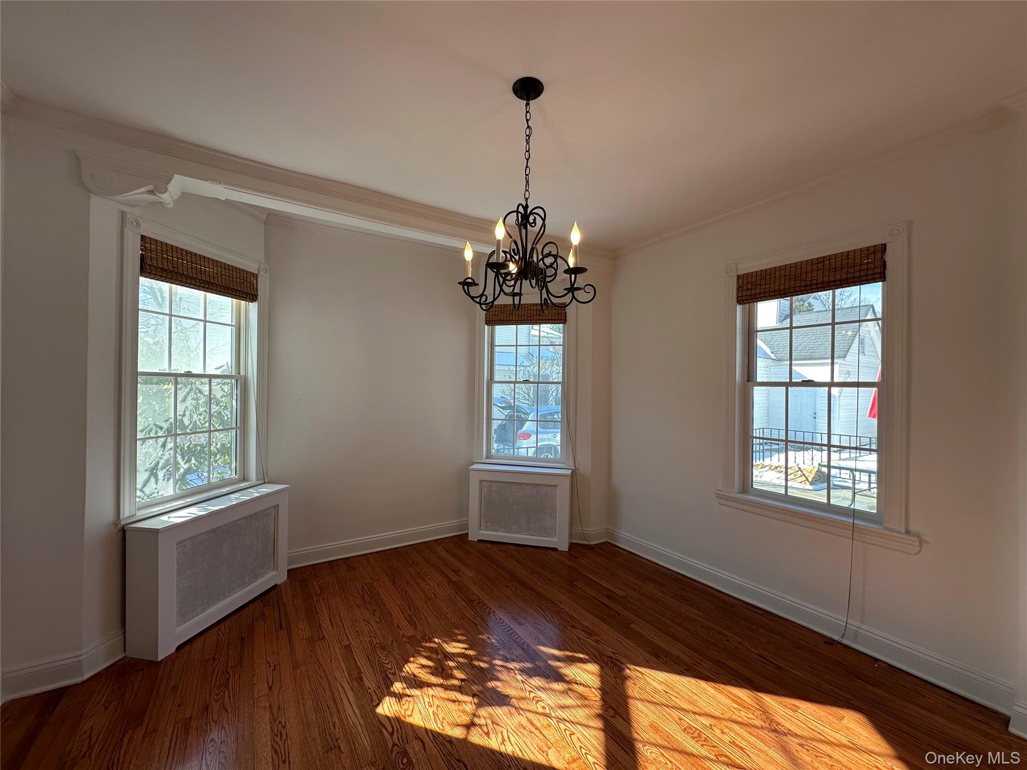 197 Johnson Road Scarsdale, NY 10583 - Photo 24 of 36 Separate Dining room featuring radiator heating unit, ornamental molding, a wealth of natural light, and dark hardwood / wood-style flooring