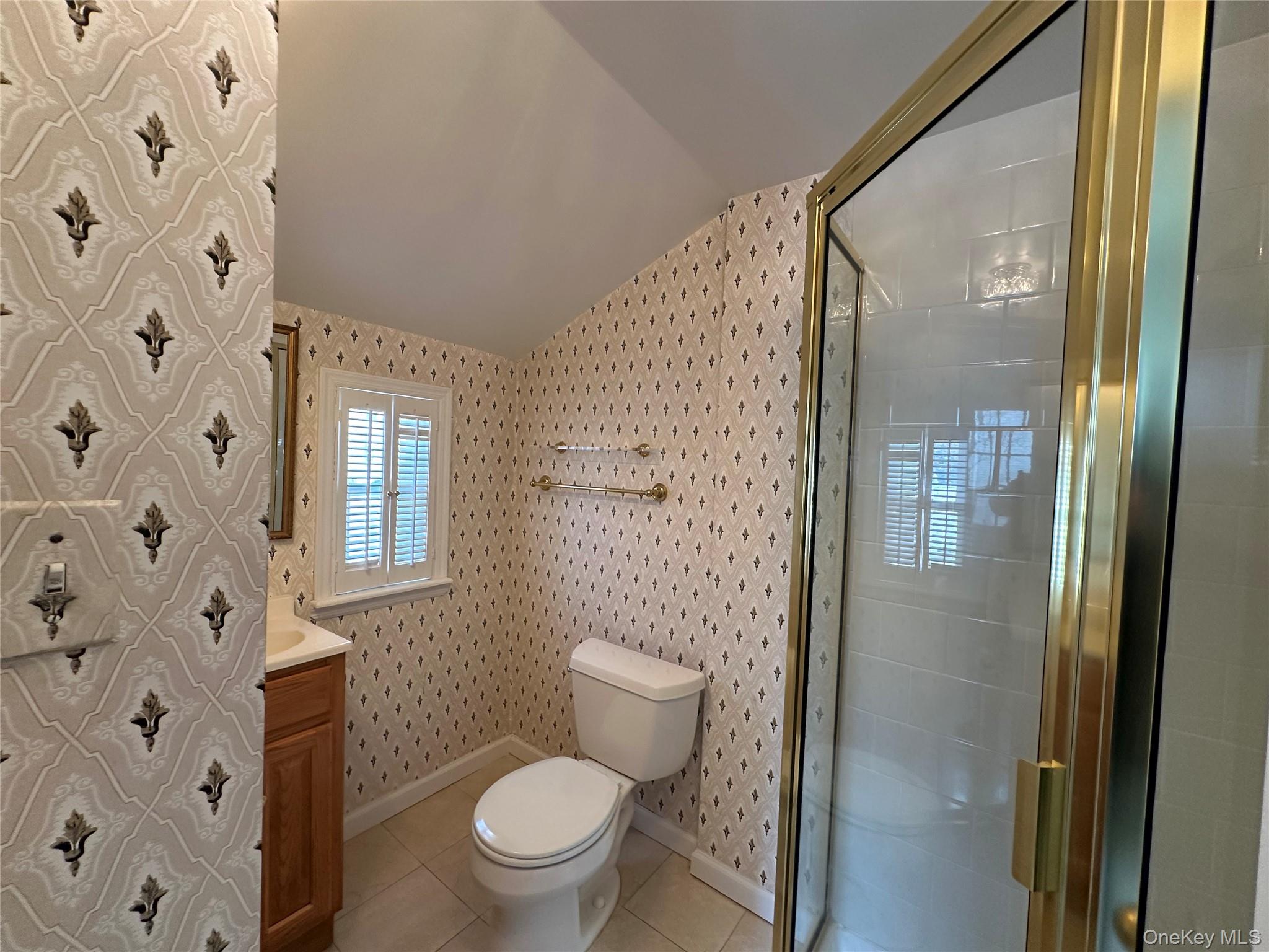 197 Johnson Road Scarsdale, NY 10583 - Photo 27 of 36 Bathroom with lofted ceiling, tile patterned floors, toilet, a shower with shower door, and vanity