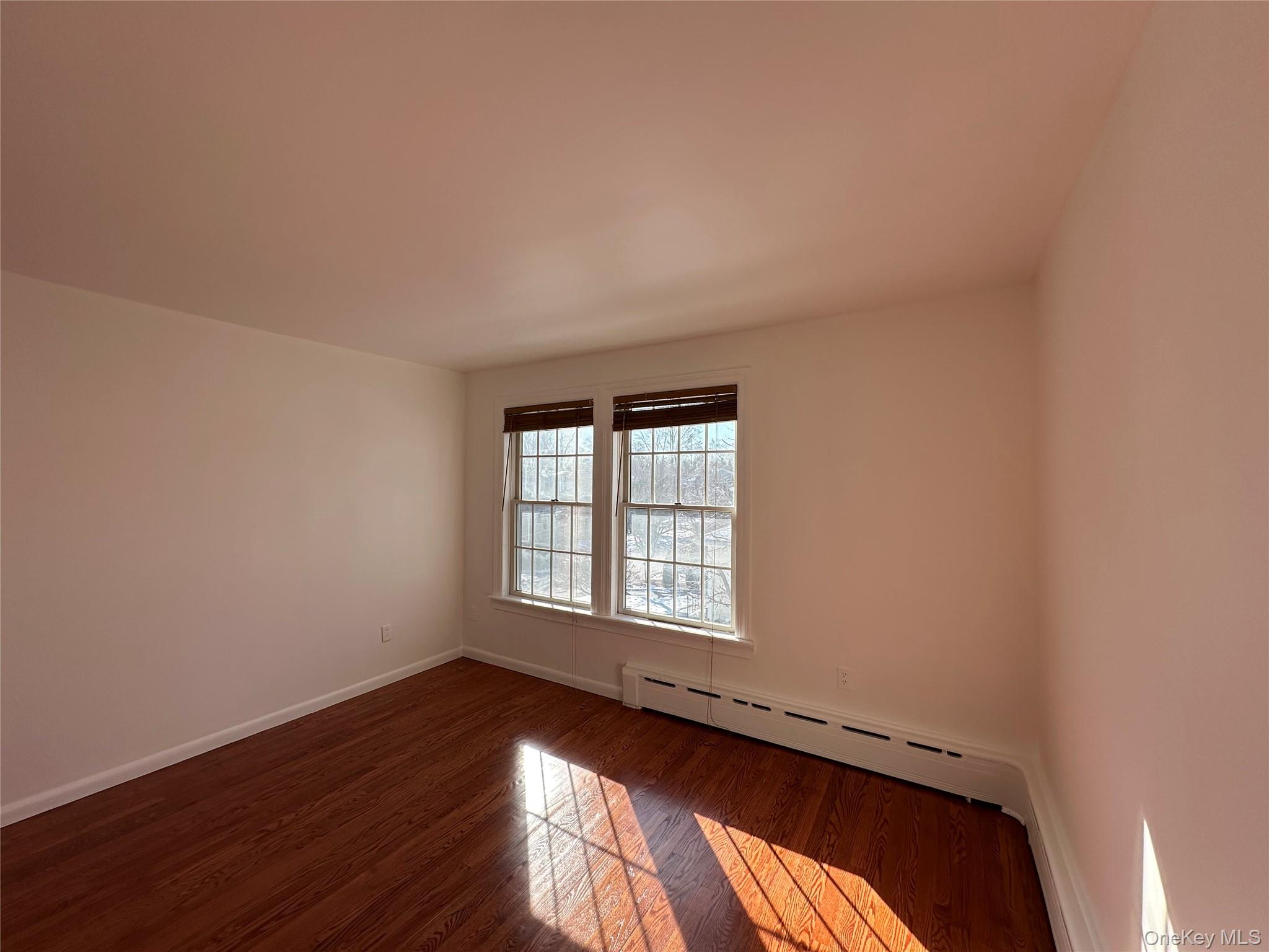 197 Johnson Road Scarsdale, NY 10583 - Photo 6 of 36 Bedroom featuring dark hardwood / wood-style flooring and a baseboard heating unit