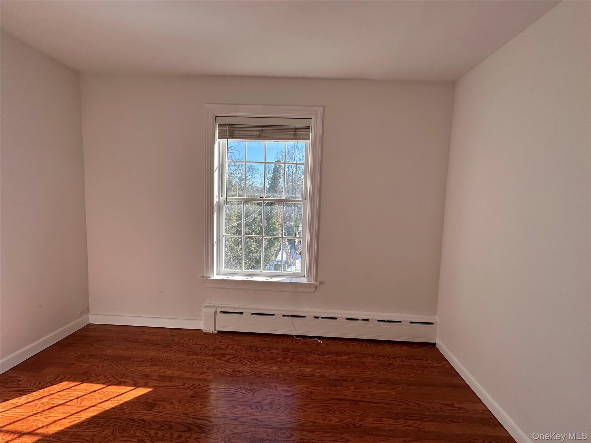 197 Johnson Road Scarsdale, NY 10583 - Photo 10 of 36 Bedroom with a baseboard radiator and dark wood-type flooring