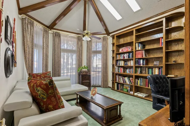 a bedroom with a bed couch and a ceiling fan