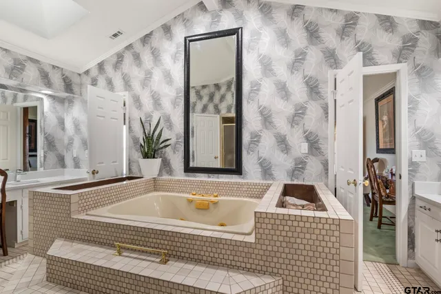 a spacious bathroom with a granite countertop tub sink and mirror