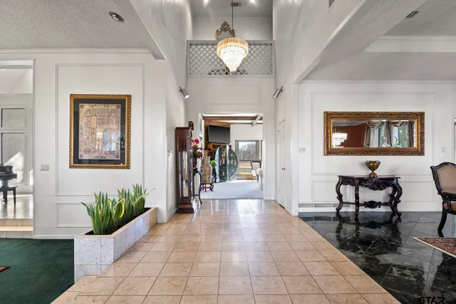 a living room with furniture and a chandelier