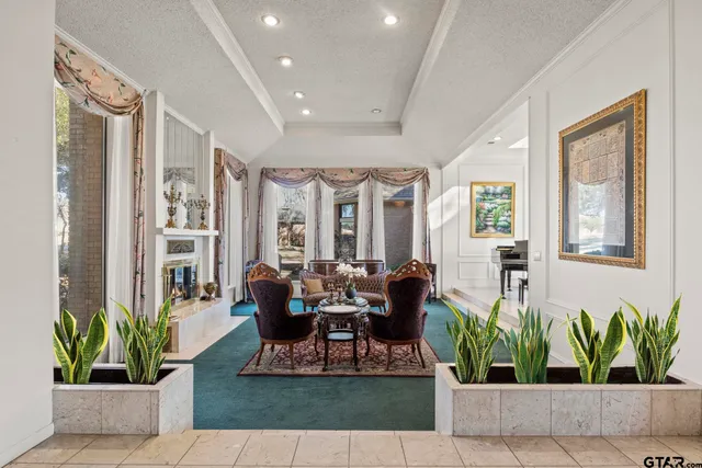 a living room with furniture potted plant and floor to ceiling windows