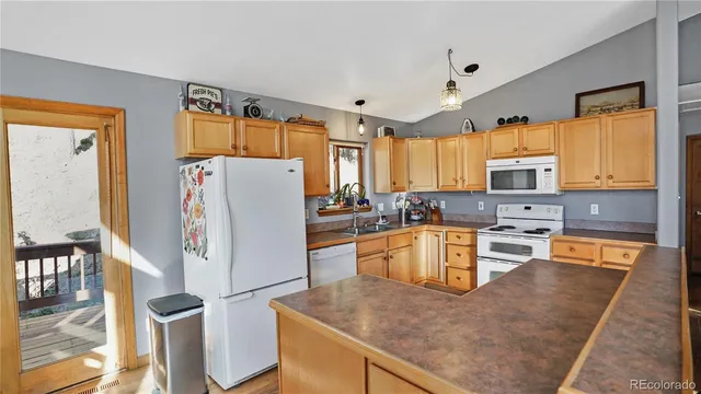a kitchen with granite countertop a refrigerator stove top oven and sink