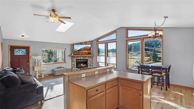 a living room with fireplace furniture and a large window
