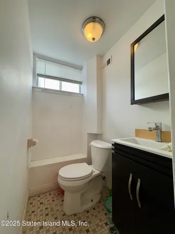 a bathroom with a toilet a sink and mirror