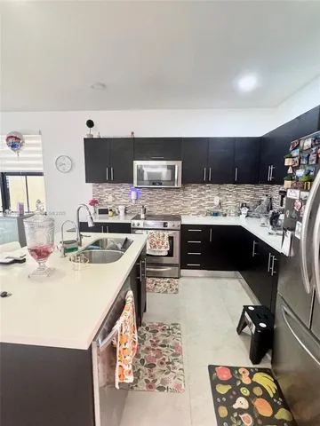 a kitchen with kitchen island a stove a sink and a refrigerator