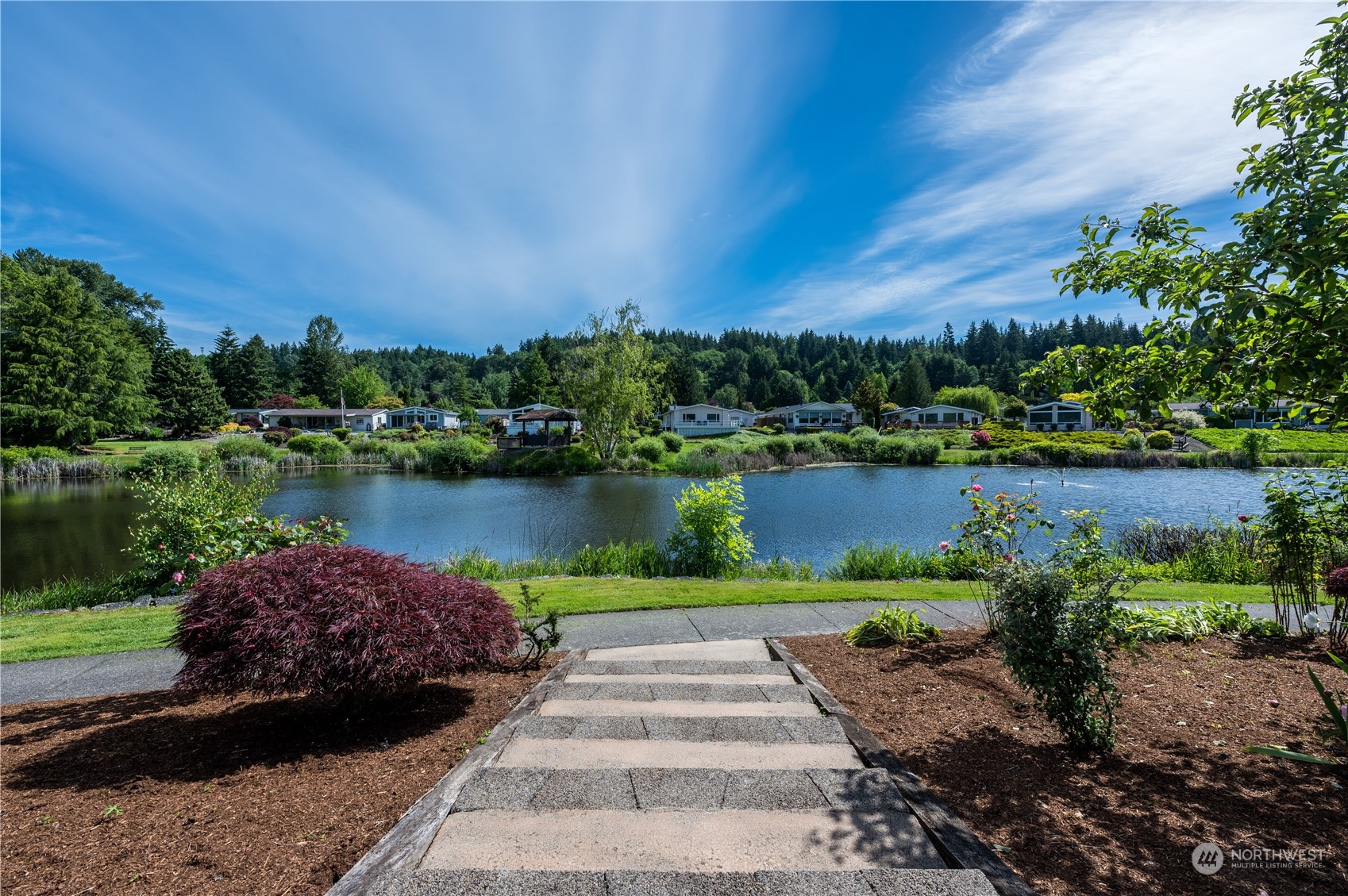 23803 Lake Drive West Bothell, WA 98021 - Photo 1 of 32 a view of a lake with a garden and houses in the back