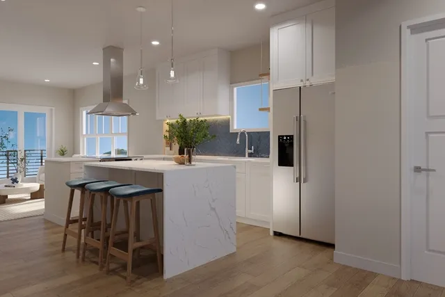 a kitchen with kitchen island granite countertop a table chairs refrigerator and microwave