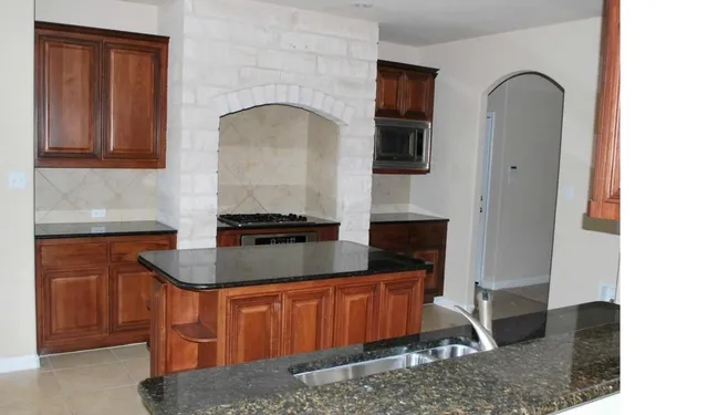 a kitchen with stainless steel appliances granite countertop a sink a stove and a refrigerator
