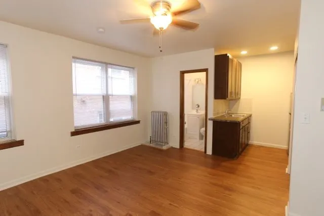 a view of a kitchen with wooden floor and a window