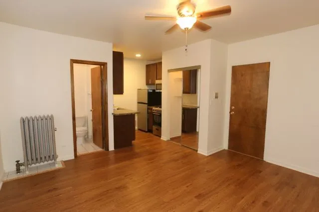 a view of a kitchen with a refrigerator a sink a kitchen wooden floor and a refrigerator
