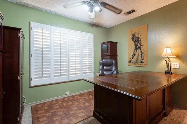a view of a workspace with furniture and a window