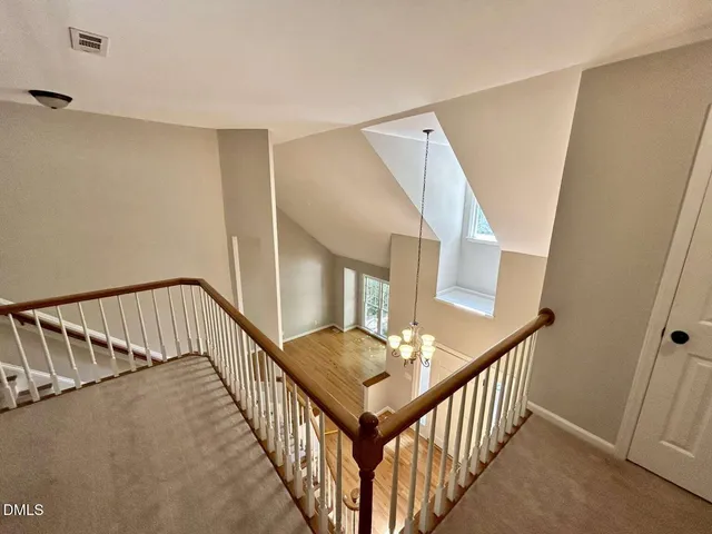 a view of staircase with railing and white walls