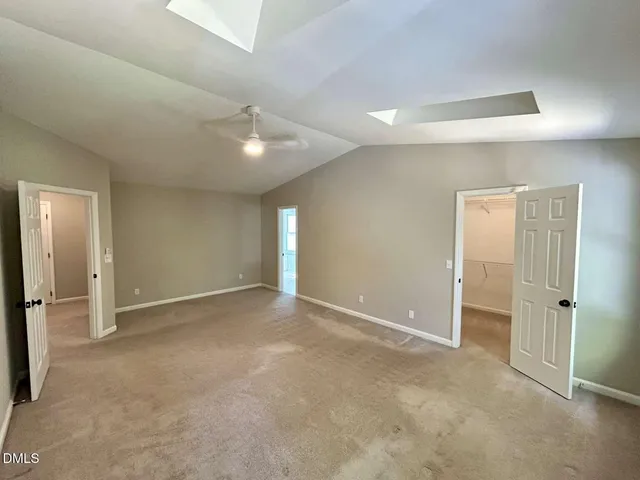 an empty room with closet and a ceiling fan