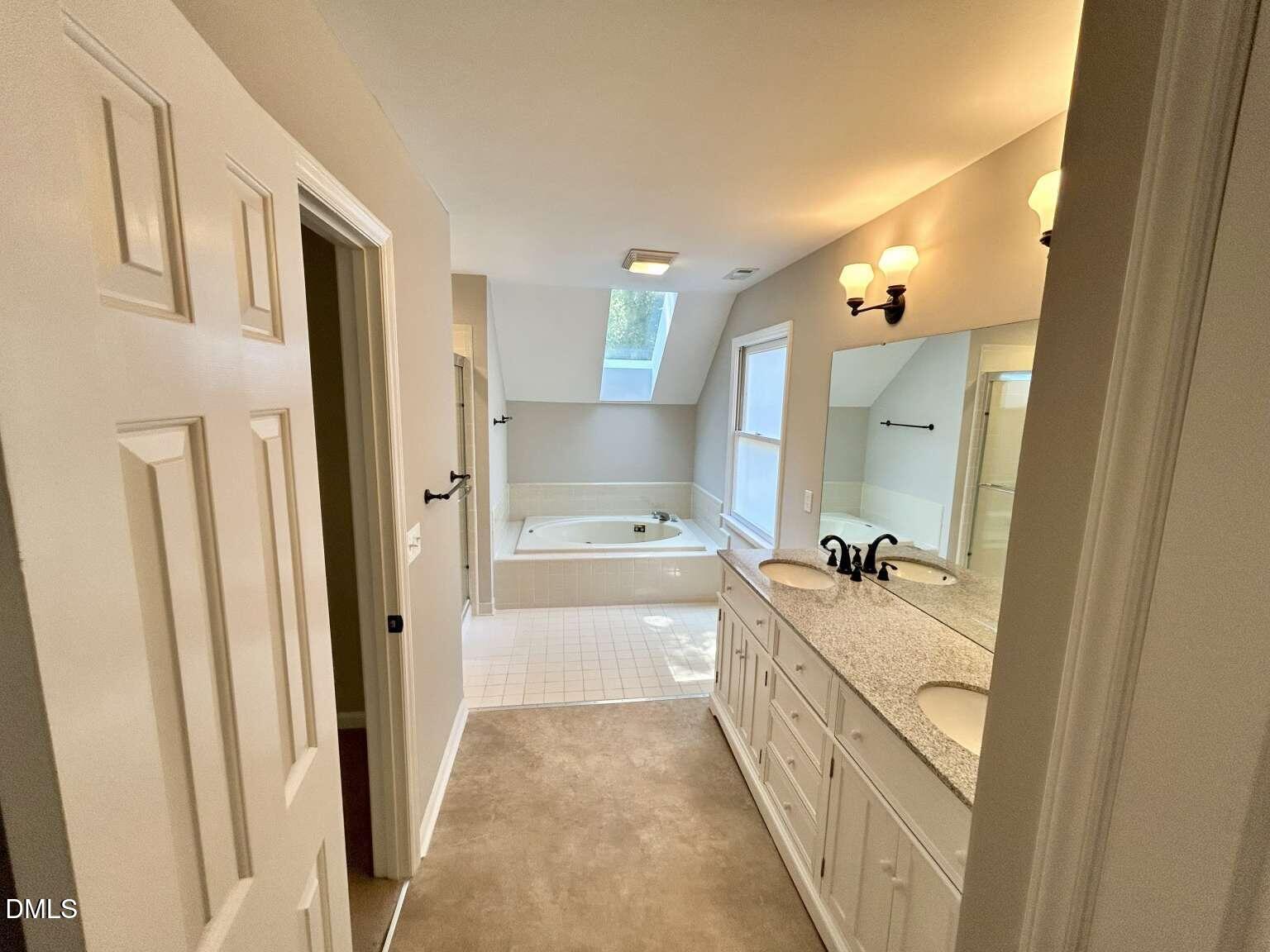 113 Ravenna Way Cary, NC 27513 - Photo 18 of 39 a bathroom with a double vanity sink a mirror and a bathtub