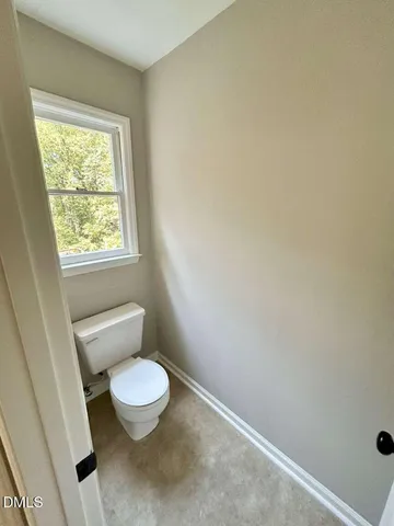 a white toilet sitting next to a window