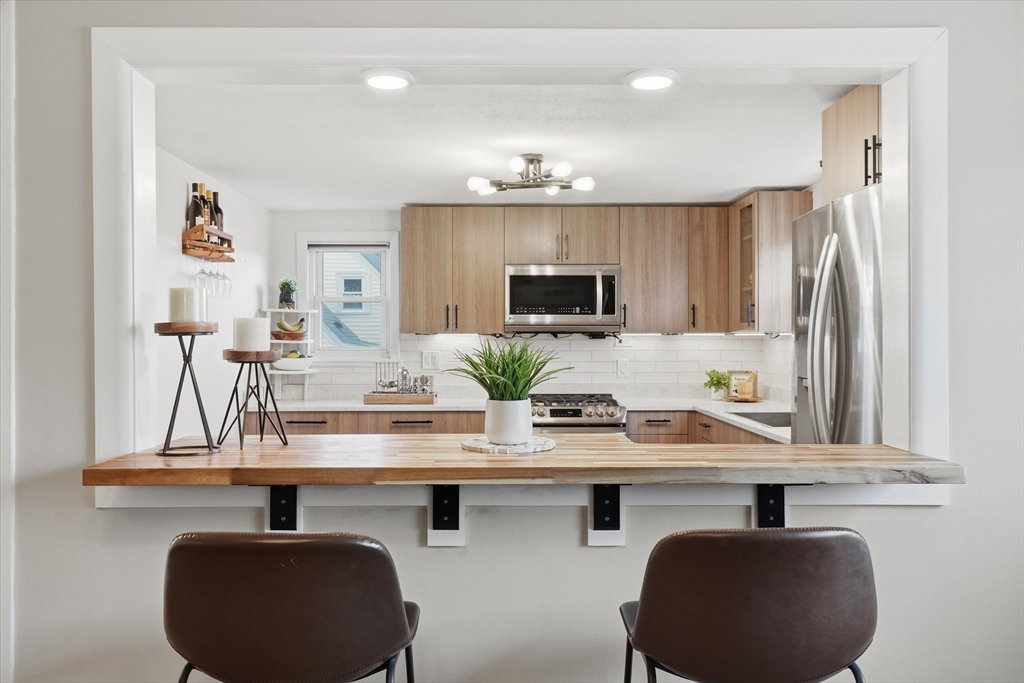27 Garfield Avenue Saugus, MA 01906 - Photo 5 of 41 a kitchen with kitchen island granite countertop a sink and cabinets