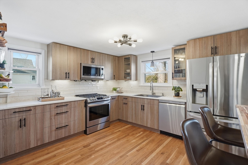 27 Garfield Avenue Saugus, MA 01906 - Photo 7 of 41 a kitchen with stainless steel appliances granite countertop a stove top oven a refrigerator a sink and dishwasher