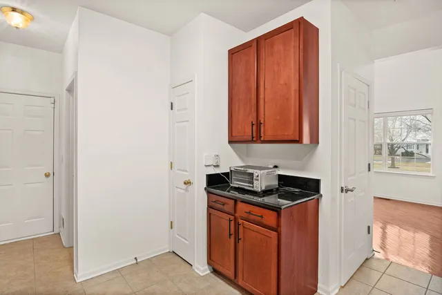 a utility room with stainless steel appliances granite countertop a stove a sink and a microwave