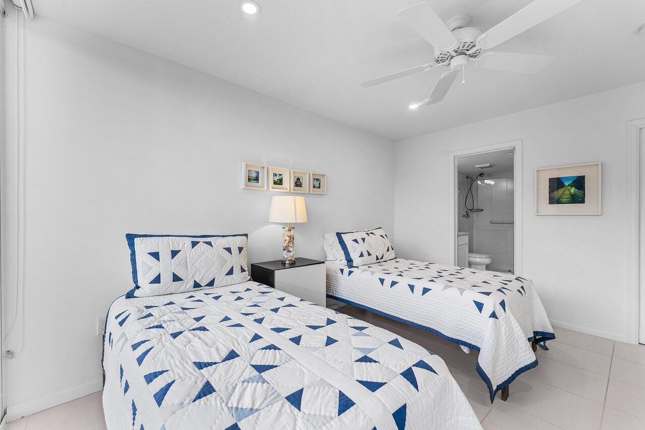 2774 South Ocean Boulevard, Unit 409 Palm Beach, FL 33480 - Photo 13 of 32 a bedroom with two beds and a chandelier
