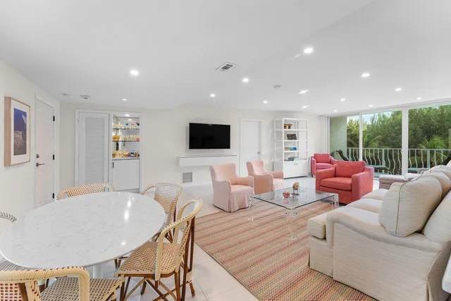 a living room with furniture kitchen view and a large window