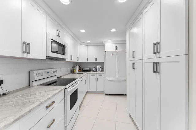 a kitchen with white cabinets and white appliances