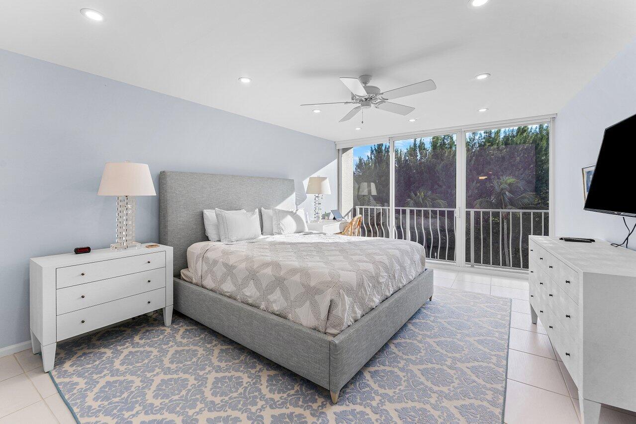 2774 South Ocean Boulevard, Unit 409 Palm Beach, FL 33480 - Photo 8 of 32 a bedroom with a bed and a flat screen tv