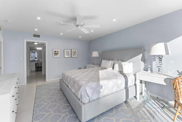 a spacious bedroom with a bed and a lamp