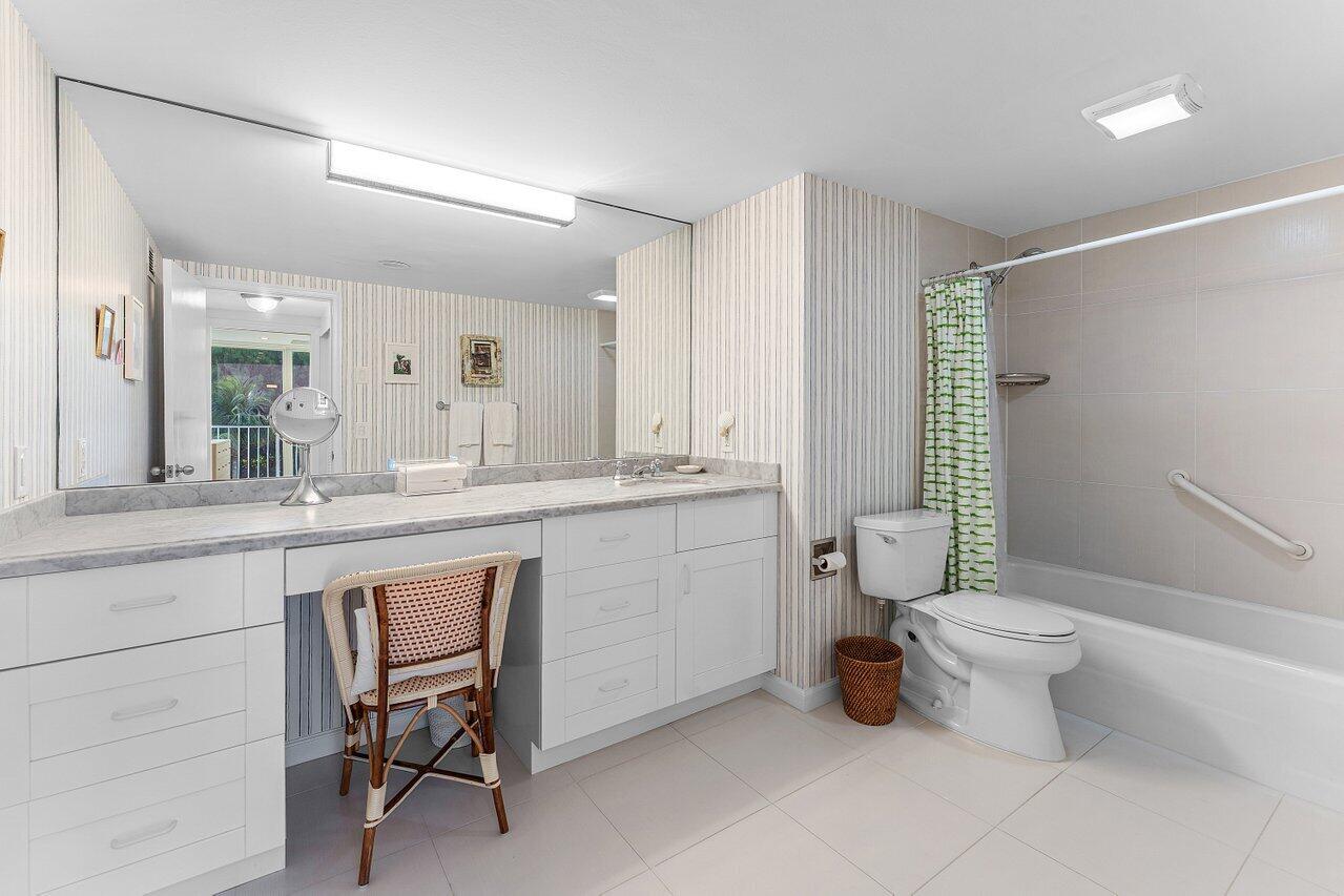 2774 South Ocean Boulevard, Unit 409 Palm Beach, FL 33480 - Photo 10 of 32 a bathroom with a toilet sink and mirror